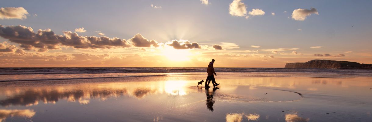 Couple waling their dog on Compton beach, Isle of Wight